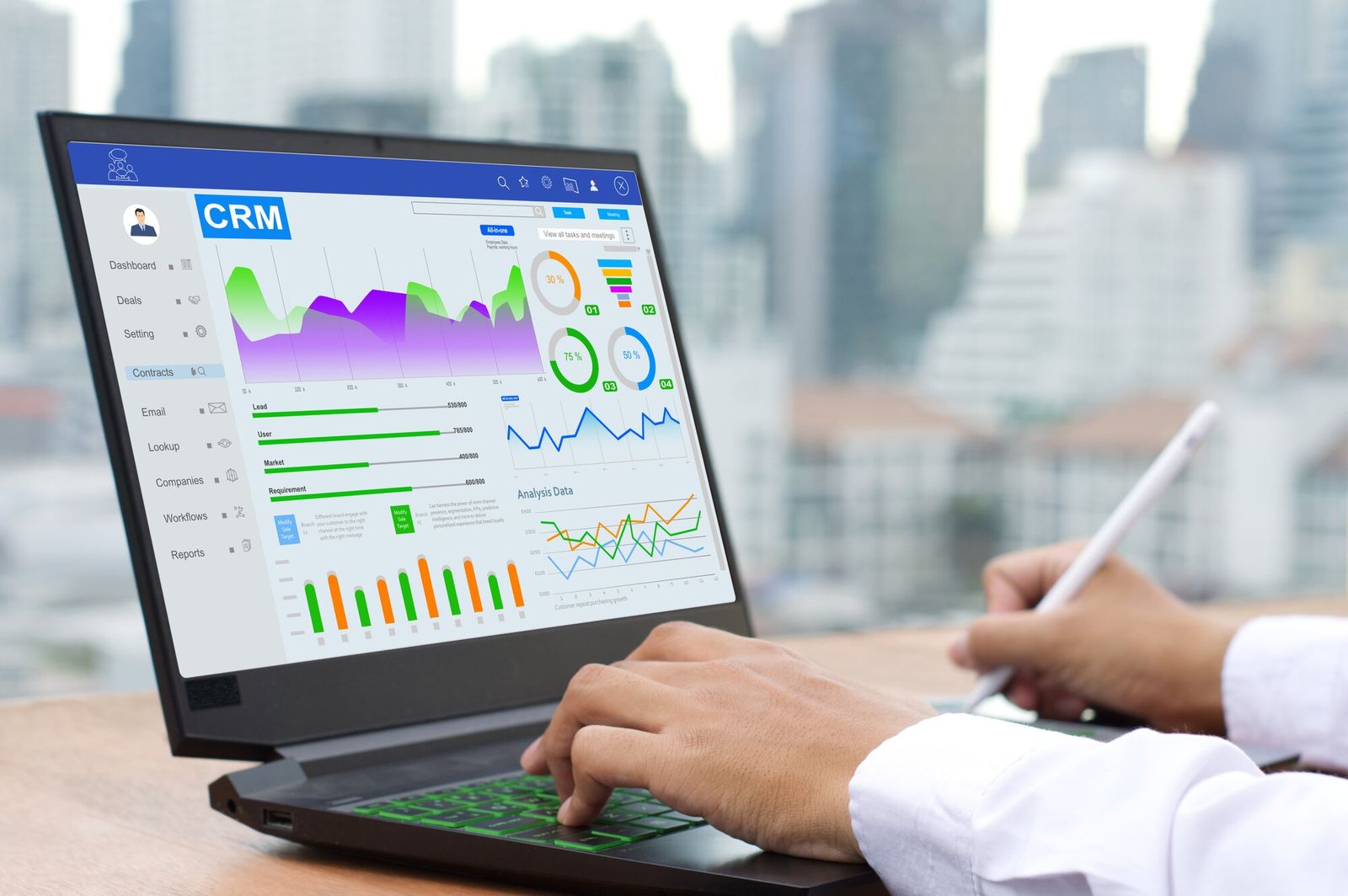 Symbolbild CRM: Person sitzt vor Laptop mit geöffnetem CRM-Dashboard