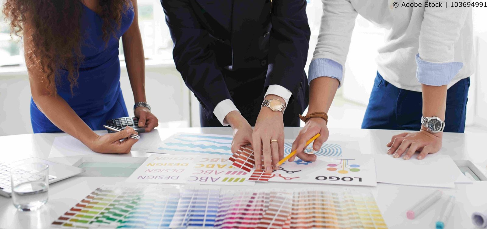 Drei Personen, die an einem Corporate Design arbeiten