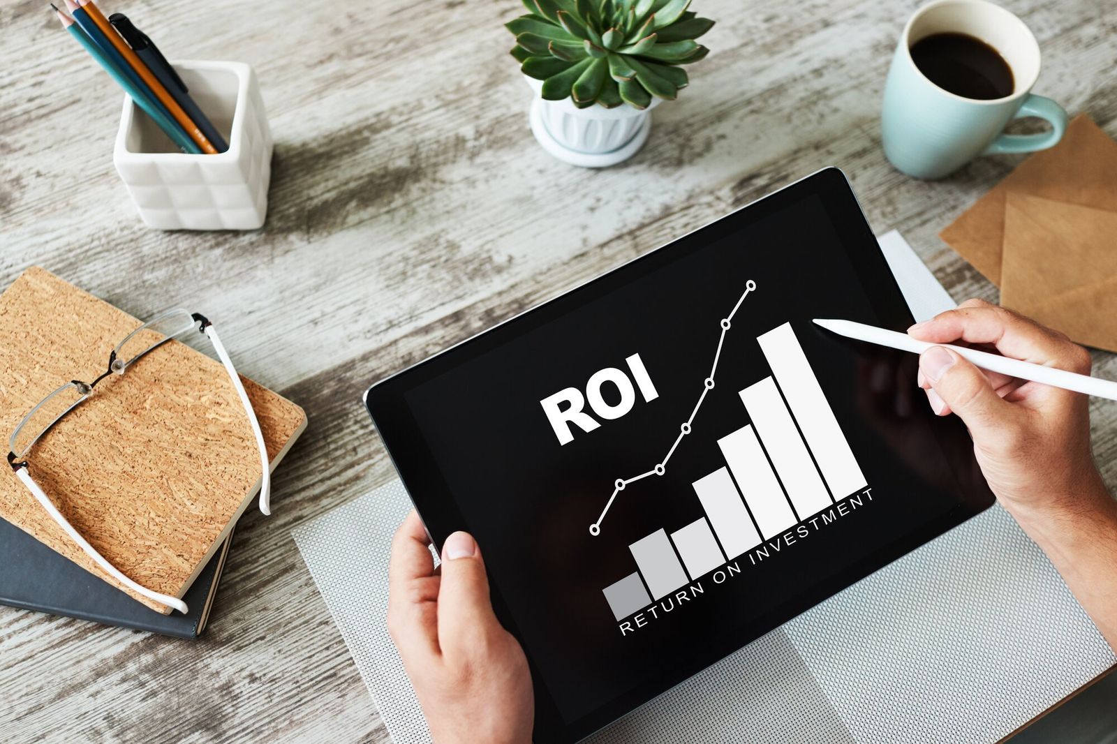 Tablet welches "ROI" anzeigt, sowie ein Balkendiagramm welches von links nach rechts immer höher wird.